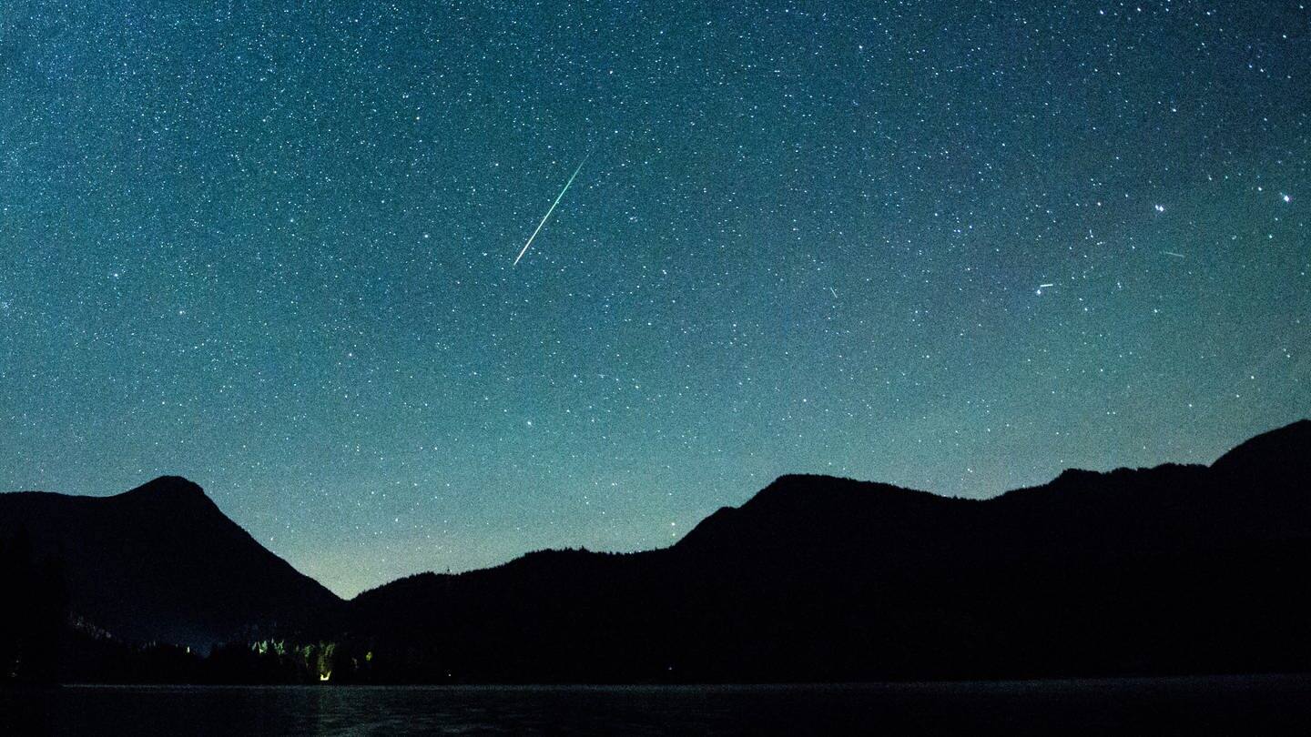 Eine Sternschnuppe leuchtet am 12.08.2018 am Himmel über dem Walchensee (Archiv). (Foto: dpa Bildfunk, picture alliance/dpa | Matthias Balk)