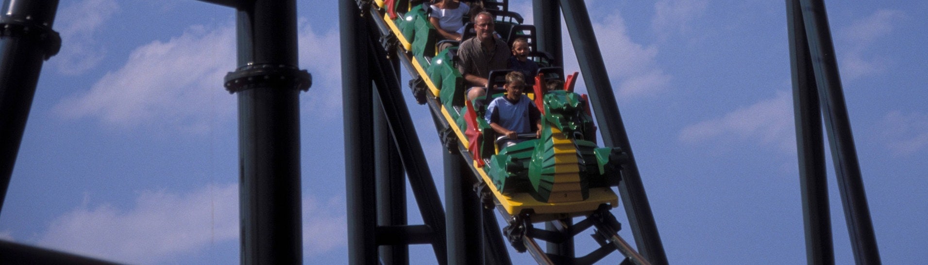 Blick auf einen vollbesetzten Waggon der Achterbahn Feuerdrache im Legoland - Günzburg. Dre Waggon fährt abwärts. (Foto: IMAGO, IMAGO / Sabine Stallmann)