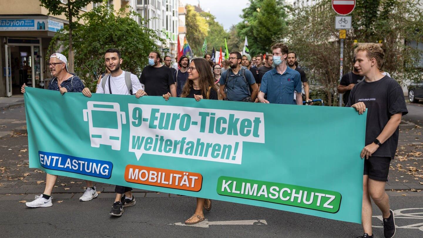 Demonstraten tragen einen Banner mit der Aufschrift „9-Euro-Ticket weiterfahren!“. (Foto: dpa Bildfunk, picture alliance/dpa | Hannes P. Albert)
