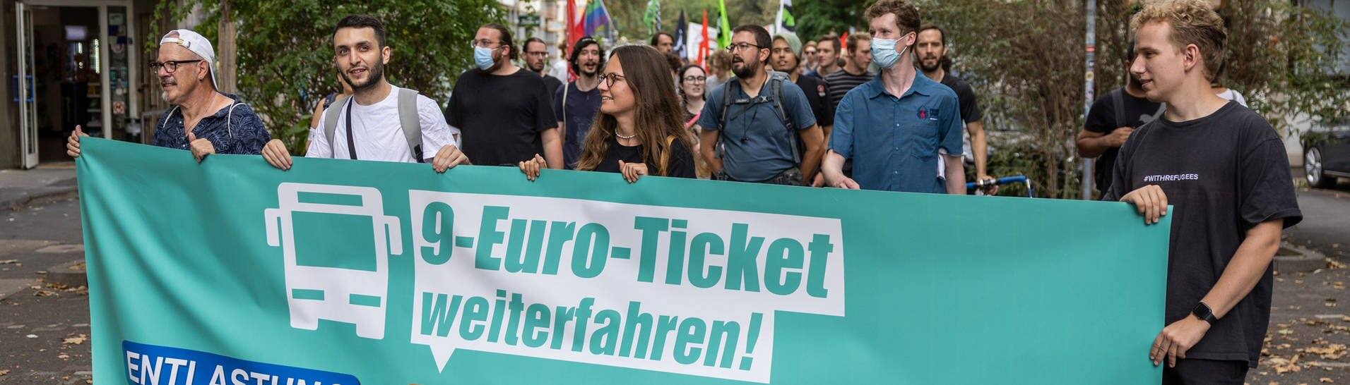 Demonstraten tragen einen Banner mit der Aufschrift „9-Euro-Ticket weiterfahren!“. (Foto: dpa Bildfunk, picture alliance/dpa | Hannes P. Albert)