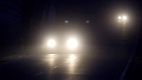Auto kommt nachts mit eingeschaltetem Fernlicht entgegen (Foto: IMAGO, Jens Koehler)
