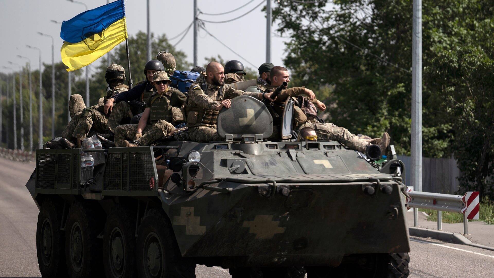 Ukrainische Soldaten fahren auf einem gepanzerten Fahrzeug auf einer Straße. (Foto: dpa Bildfunk, picture alliance/dpa/AP | Leo Correa)