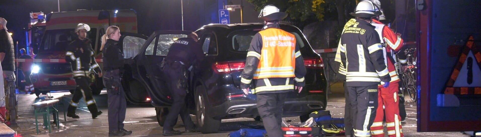 Einsatzkräfte der Polizei und Feuerwehr sowie Rettungskräfte stehen im Rüsselsheimer Ortsteil Bauschheim an der Unfallstelle, nachdem ein Mann mit dem Auto in eine Gruppe gefahren ist und mehrere Menschen verletzt werden wurden.  (Foto: dpa Bildfunk, picture alliance/dpa/Keutz-TVNews | Keutz-TVNews)