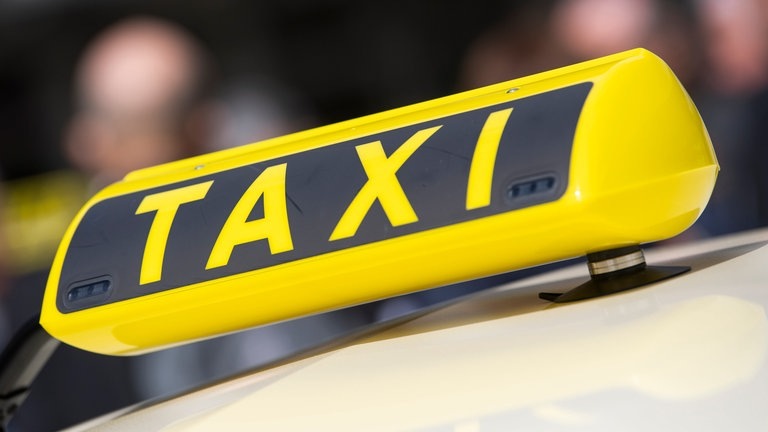 Großes Taxischild auf einem Taxi. (Foto: dpa Bildfunk, picture alliance/dpa | Christophe Gateau)