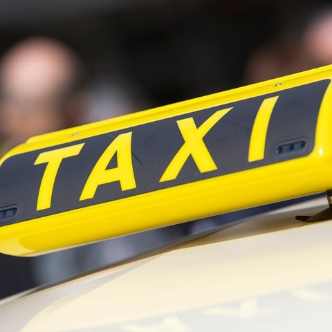 Großes Taxischild auf einem Taxi. (Foto: dpa Bildfunk, picture alliance/dpa | Christophe Gateau)