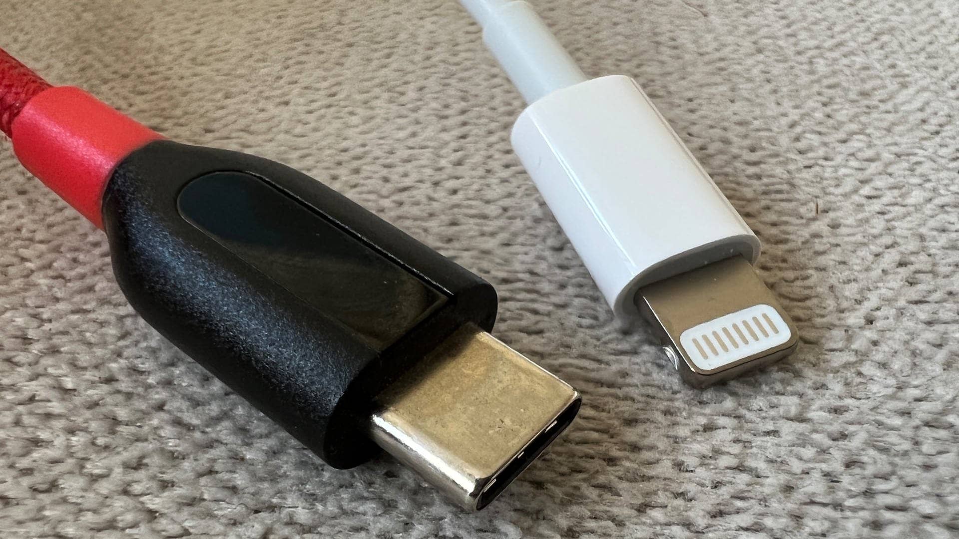 Ein rot-schwarzes Kabel mit einem USB-C-Stecker und ein Lightning-Stecker von Apple an einem weißen Kabel.  (Foto: dpa Bildfunk, picture alliance/dpa | Christoph Dernbach)