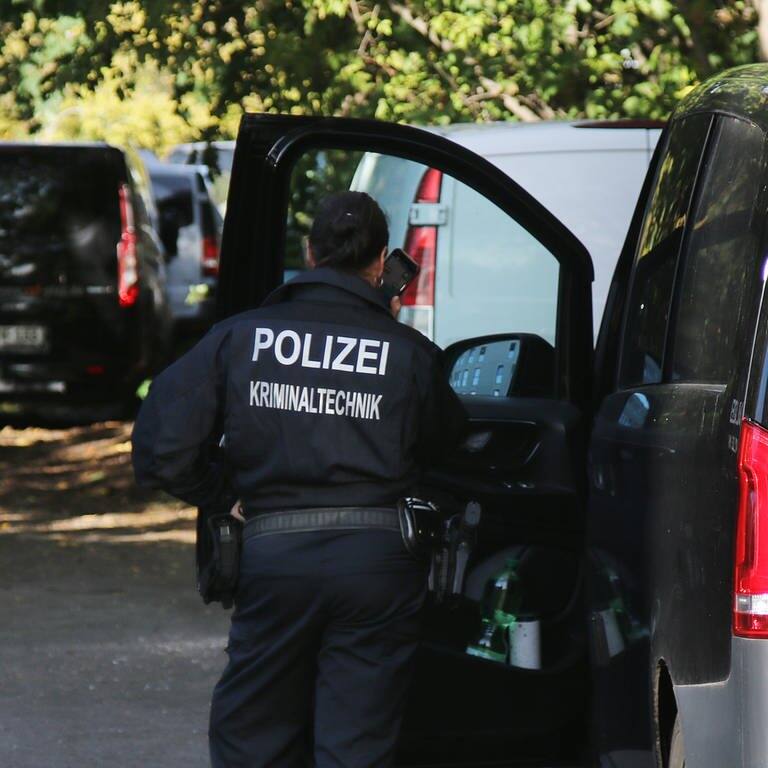 Eine Kriminaltechnikerin steht in der Nähe vom S-Bahnhof Hohenschönhausen neben Fahrzeugen der Polizei.  (Foto: dpa Bildfunk, picture alliance/dpa/- | John Boutin)