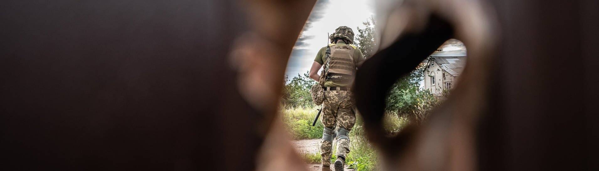 Ein ukrainischer Soldat bringt sich an der Frontlinie nahe Charkiw in Sicherheit. (Foto: dpa Bildfunk, picture alliance/dpa/ZUMA Press Wire | Hector Adolfo Quintanar Perez)