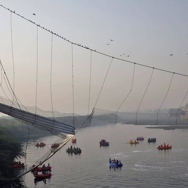 Die eingestürzte Hängebrücke im Morgengrauen, einige Rettungsboote schwimmen auf dem Fluss. (Foto: Reuters, REUTERS/Stringer)