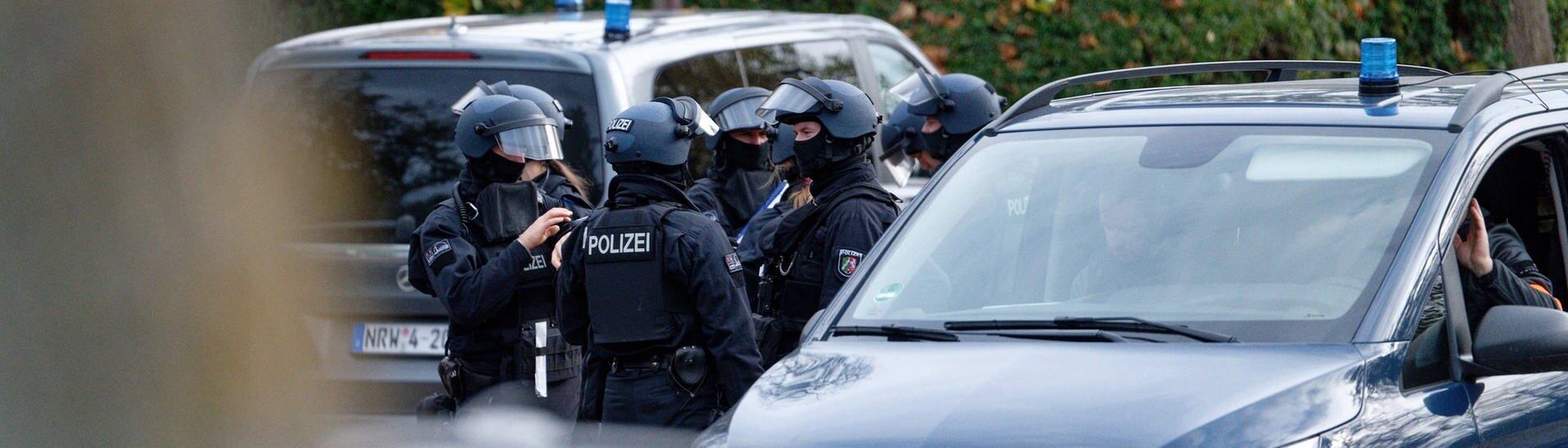 Fahrzeuge und Einsatzkräfte der Polizei stehen vor einer Realschule in Siegburg.  (Foto: dpa Bildfunk, picture alliance/dpa | Henning Kaiser)