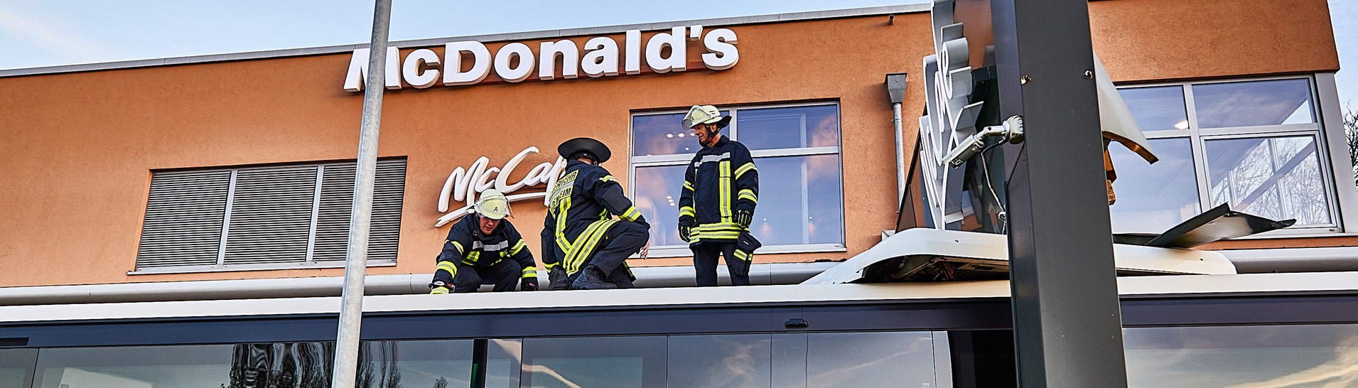 Feuerwehrleute arbeiten an und auf einem Bus, der unter einem Schild der Burgerkette McDonald's steckengeblieben ist. (Foto: dpa Bildfunk, picture alliance/dpa/onw-images | Markus Brandhuber)