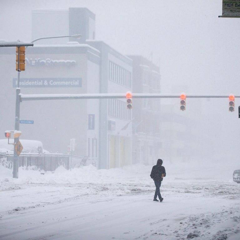 Eine Person geht über eine völlig verschneite Straße in Buffalo in den USA. (Foto: dpa Bildfunk, picture alliance/dpa/FR171816 AP | Joshua Bessex)