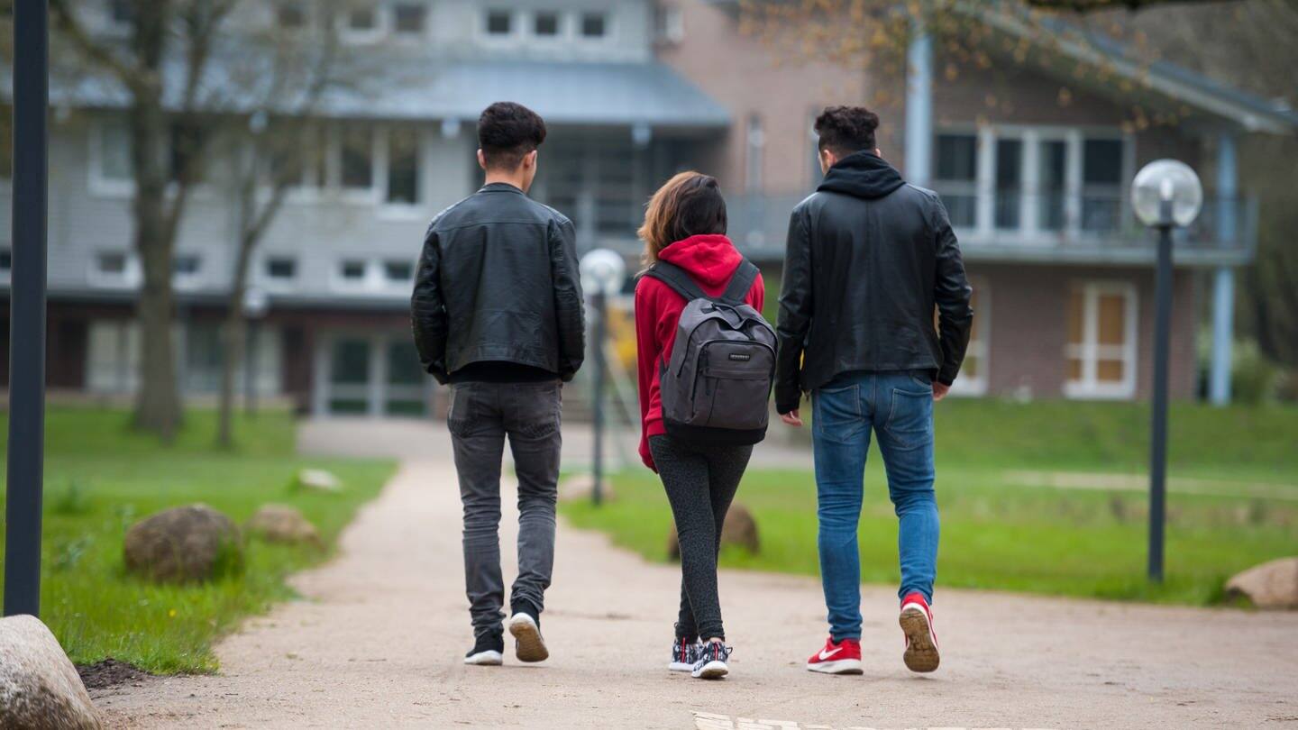 Drei Jugendliche gehen über das Gelände einer Schule. (Foto: dpa Bildfunk, picture alliance/dpa | Philipp Schulze)