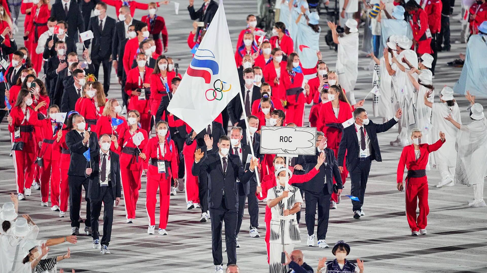 Russische Sportler laufen ins Olympiastadion. Dabei tragen sie nicht die russische Fahne, sondern die des „Russischen Olympischen Komitees“. (Foto: dpa Bildfunk, picture alliance/dpa | Michael Kappeler)