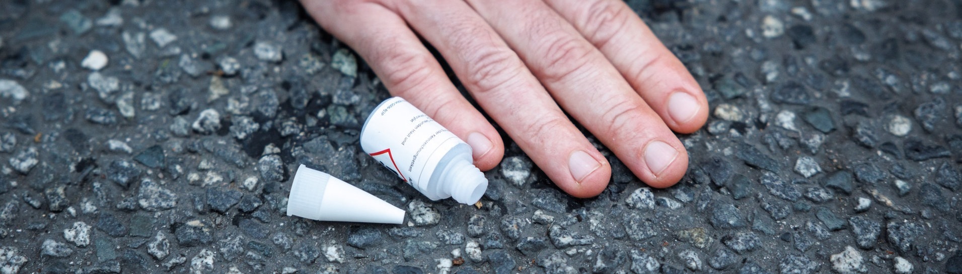 Ein Aktivist der Klimaschutz-Initiative „Letzte Generation“ hat sich am Stachus mit seiner Hand auf die Straße geklebt. Nahaufnahme der Hand. (Foto: dpa Bildfunk, picture alliance/dpa | Matthias Balk)