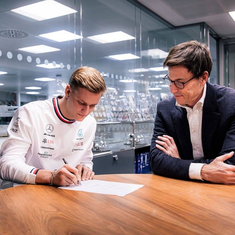 Schumacher unterschreibt bei Mercedes. Rechts neben ihm Teamchef Toto Wolff. (Foto: IMAGO, IMAGO / Kolvenbach)
