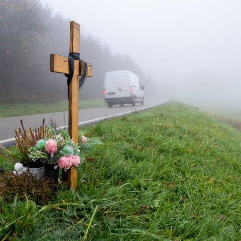 Ein Holzkreuz zum Gedenken wurde am Tatort an der K22 bei Kusel aufgestellt, wo Ende Januar 2022 zwei Polizisten im Dienst getötet wurden. (Foto: dpa Bildfunk, picture alliance/dpa | Harald Tittel)