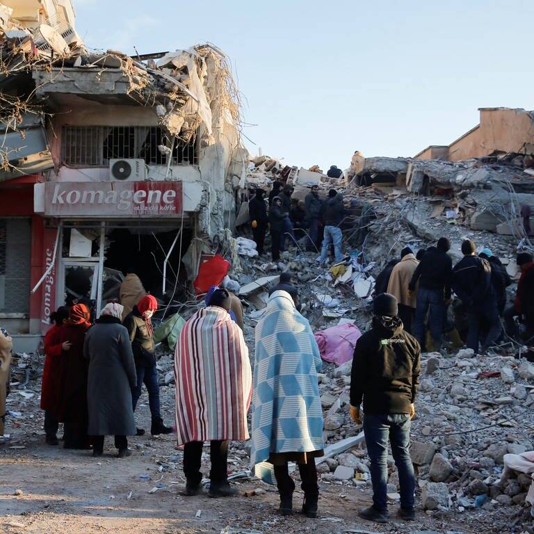 Menschen stehen vor den Trümmern eines Hauses in Kahramanmaras, Türkei. (Foto: Reuters, REUTERS/Dilara Senkaya)