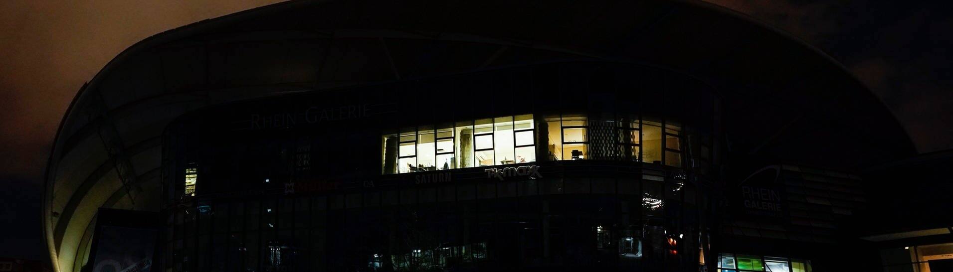 Nur wenig Licht leuchtet am Einkaufszentrum Rhein-Galerie. In Ludwigshafen ist es am Freitag zu einem Stromausfall gekommen. (Foto: dpa Bildfunk, picture alliance/dpa | Uwe Anspach)