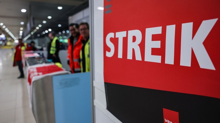 picture alliancedpa | Oliver Berg (Foto: dpa Bildfunk, „Streik“ steht in großen Lettern auf einem roten Schild der Gewerkschaft Verdi. )