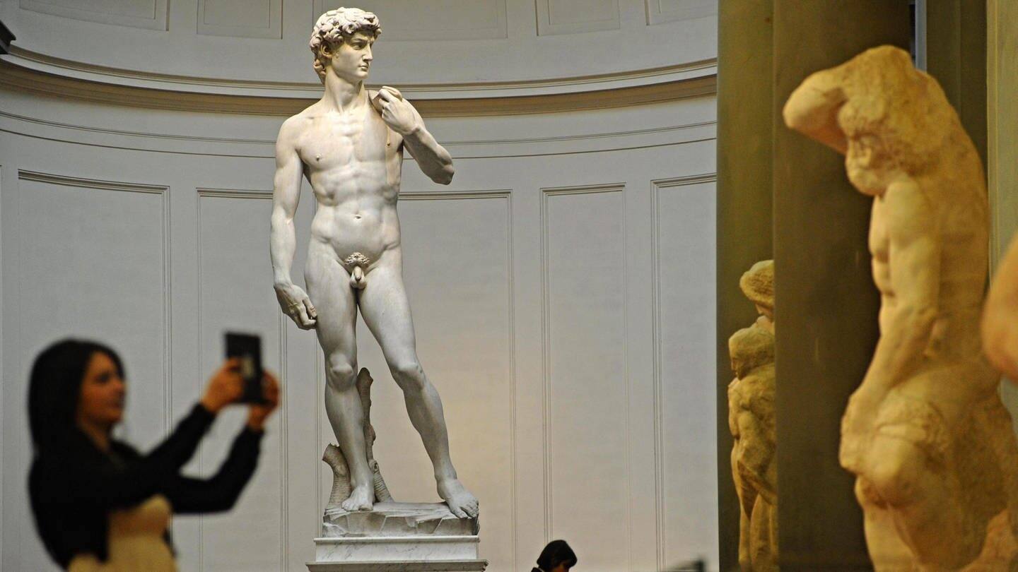 Die David-Statue von Michelangelo; im Vordergrund macht eine Museumsbesucherin in Selfie (Foto: dpa Bildfunk, picture alliance / dpa | Maurizio Degl' Innocenti)