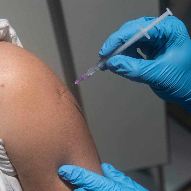 Jemand wird mit einer Spritze gegen Corona in die Schulter geimpft (Foto: dpa Bildfunk, picture alliance/dpa | Paul Zinken)