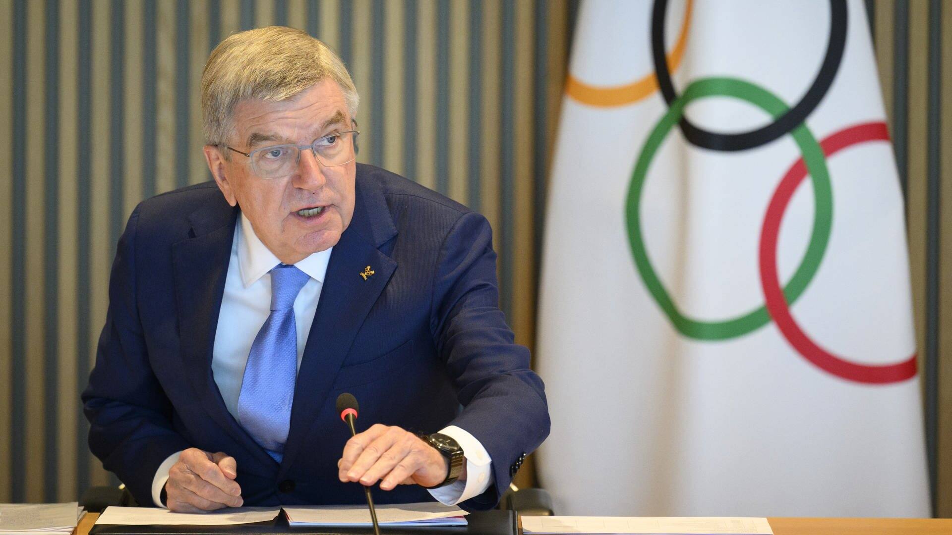 Thomas Bach, der Präsident des Internationalen Olympischen Komitees, hält eine Rede, im Hintergrund hängt eine Fahne mit den Olympischen Ringen (Foto: dpa Bildfunk, picture alliance/dpa/KEYSTONE | Laurent Gillieron)