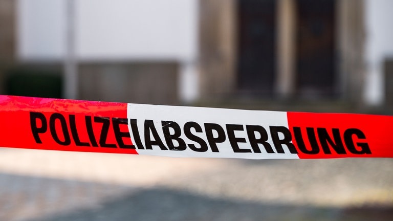 „Polizeiabsperrung“ steht auf einem rot-weißen Flatterband der Polizei.  (Foto: dpa Bildfunk, picture alliance/dpa | Daniel Vogl)