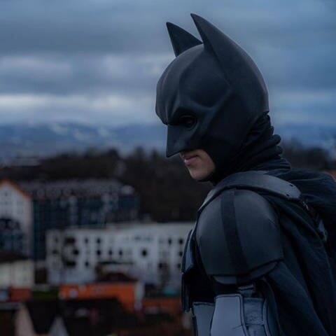 Ein als Batman verkleideter Mann steht vor der Stadtkulisse von Kempten.  (Foto: Instagram/ kempten_batman)