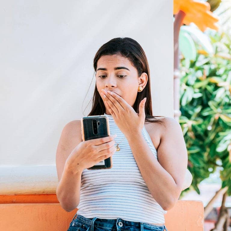 Eine Frau schaut erschrocken auf ihr Handy (Foto: IMAGO, IMAGO / imagebroker)