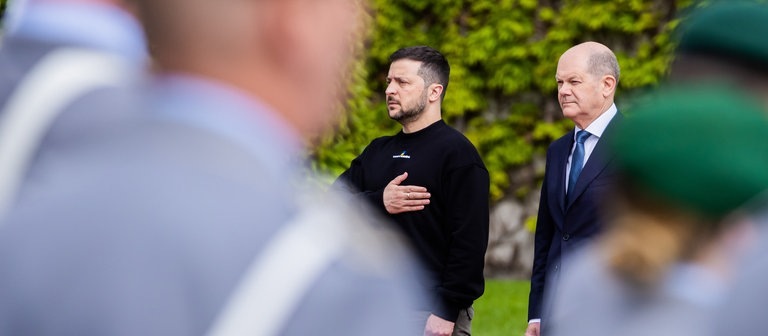 picture alliancedpa | Christoph Soeder (Foto: dpa Bildfunk, Wolodymyr Selenskyj (l), Präsident der Ukraine, wird von Bundeskanzler Olaf Scholz (SPD) vor dem Bundeskanzleramt mit militärischen Ehren begrüßt.)