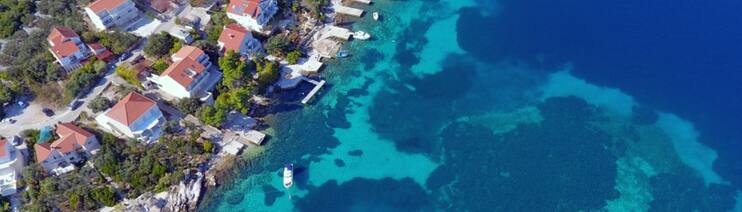 Die Küste der kroatischen Insel Korčula. Häuser stehen am tiefblauen Meer. Hier haben Taucher eine 7.000 Jahre alte Straße entdeckt. (Foto: Facebook/ Universität Zadar)