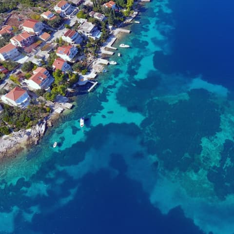 Die Küste der kroatischen Insel Korčula. Häuser stehen am tiefblauen Meer. Hier haben Taucher eine 7.000 Jahre alte Straße entdeckt. (Foto: Facebook/ Universität Zadar)