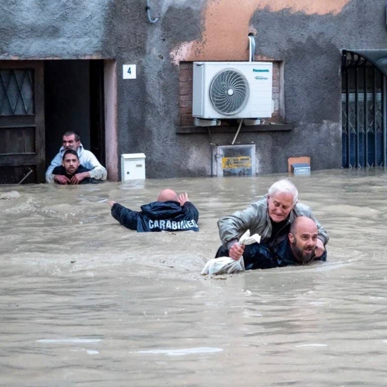 Überschwemmungen in Italien: Carabinieri tragen Anwohner huckepack durch die überschwemmten Straßen. (Foto: dpa Bildfunk, picture alliance/dpa/Arma dei Carabinieri | -)