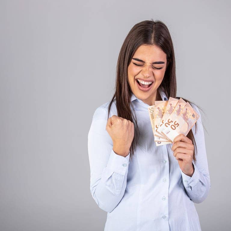 Eine junge Frau hält 50-Euro-Scheine in der Hand und freut sich (Foto: Adobe Stock | Dragana Gordic)