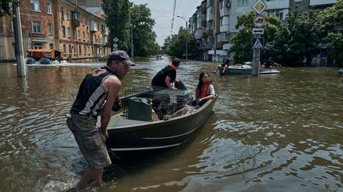 Menschen mit Haustieren werden mit einem Boot aus einem überfluteten Stadtteil evakuiert. In den Fluten sind mindestens 14 Menschen gestorben. (Foto: dpa Bildfunk, Picture Alliance)