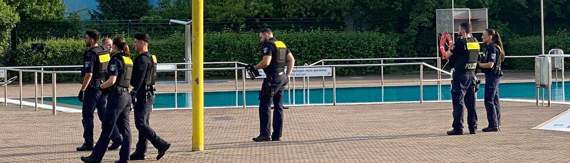 Polizisten stehen vor dem Schwimmbecken: Das Sommerbad Neukölln am Columbiadamm wurde am Mittwochabend von Polizisten geräumt.  (Foto: dpa Bildfunk, picture alliance/dpa | Andreas Rabenstein)