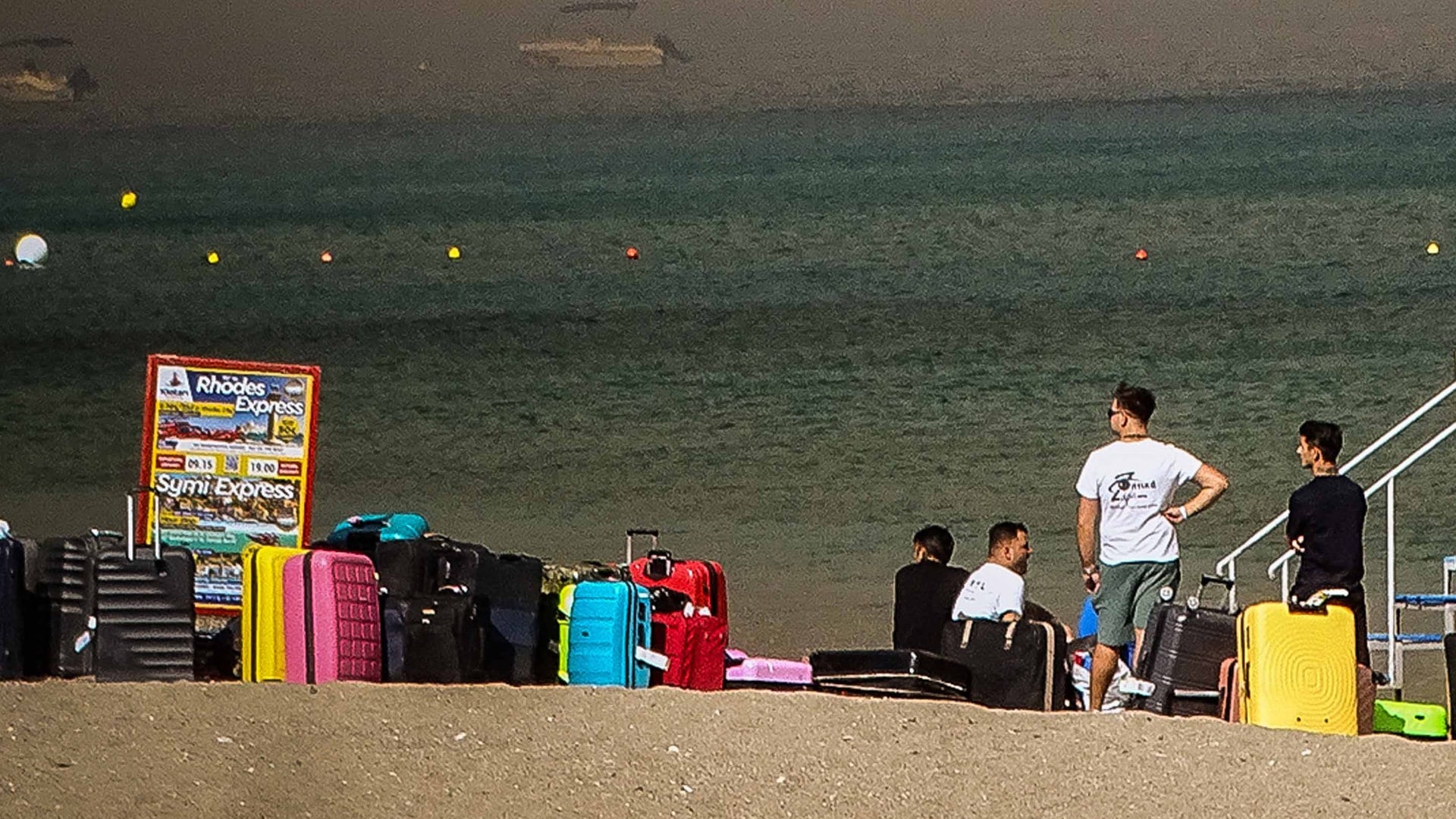 Foto: dpa Bildfunk, picture alliance/dpa/XinHua | Argiris Mantikos Welche BIlder sind fake, welche KI-generiert? Menschen warten auf der griechischen Insel Rhodos darauf, vor den katastrophalen Waldbränden in Sicherheit gebracht zu werden. (Foto: dpa Bildfunk, picture alliance/dpa/XinHua | Argiris Mantikos)