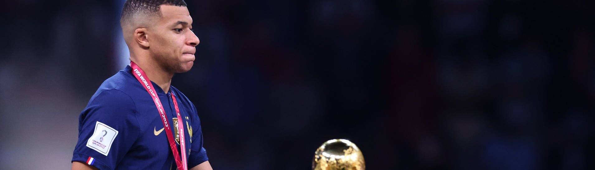 Fußball, WM 2022 in Katar, Argentinien - Frankreich, Finale, im Lusail Stadion, Frankreichs Kylian Mbappe steht neben dem Weltmeisterpokal. (Foto: dpa Bildfunk, picture alliance/dpa | Tom Weller)