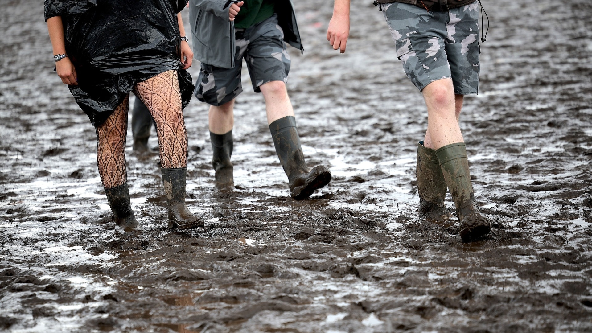 Foto: dpa Bildfunk, picture alliance/dpa | Christian Charisius Festivalbesucher laufen mit Gummistiefeln durch den Matsch bei Wacken (Foto: dpa Bildfunk, picture alliance/dpa | Christian Charisius)