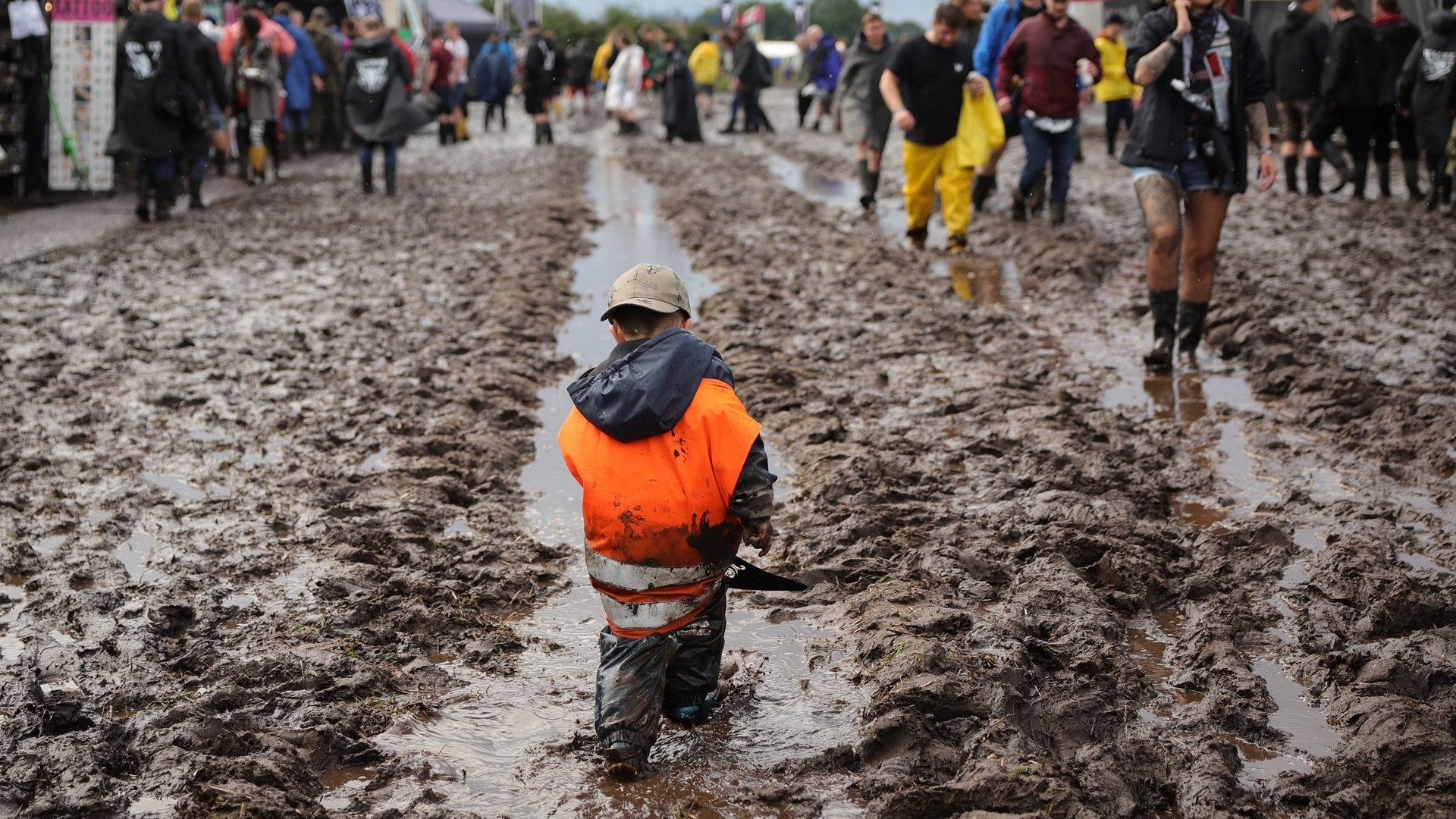 Foto: dpa Bildfunk, picture alliance/dpa | Christian Charisius Ein Kind läuft durch den Schlamm bei Wacken (Foto: dpa Bildfunk, picture alliance/dpa | Christian Charisius)