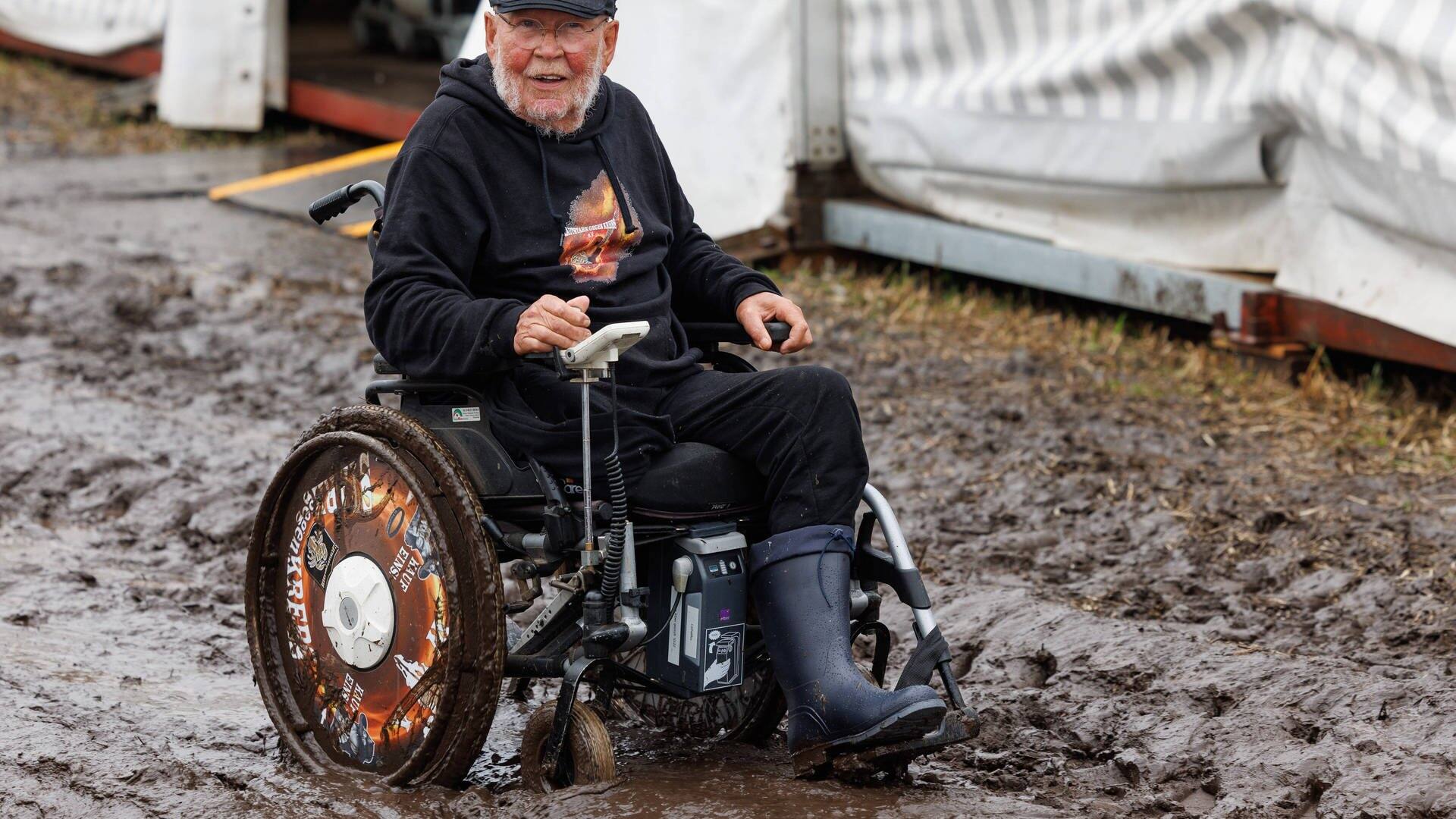 Wacken-Opa Günter, der für seine Charity-Organisation „Lautstark gegen den Krebs“ sammelt, lässt sich trotz Rollstuhl nicht vom Matsch aufhalten. (Foto: IMAGO, IMAGO/Dirk Jacobs)