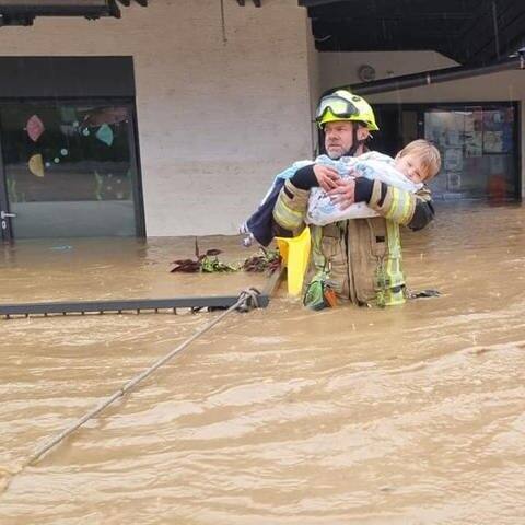 Feuerwehrmann Sandi Zajc trägt ein Kind aus einem überfluteten Kindergarten (Foto: Facebook / Darko Žigon)