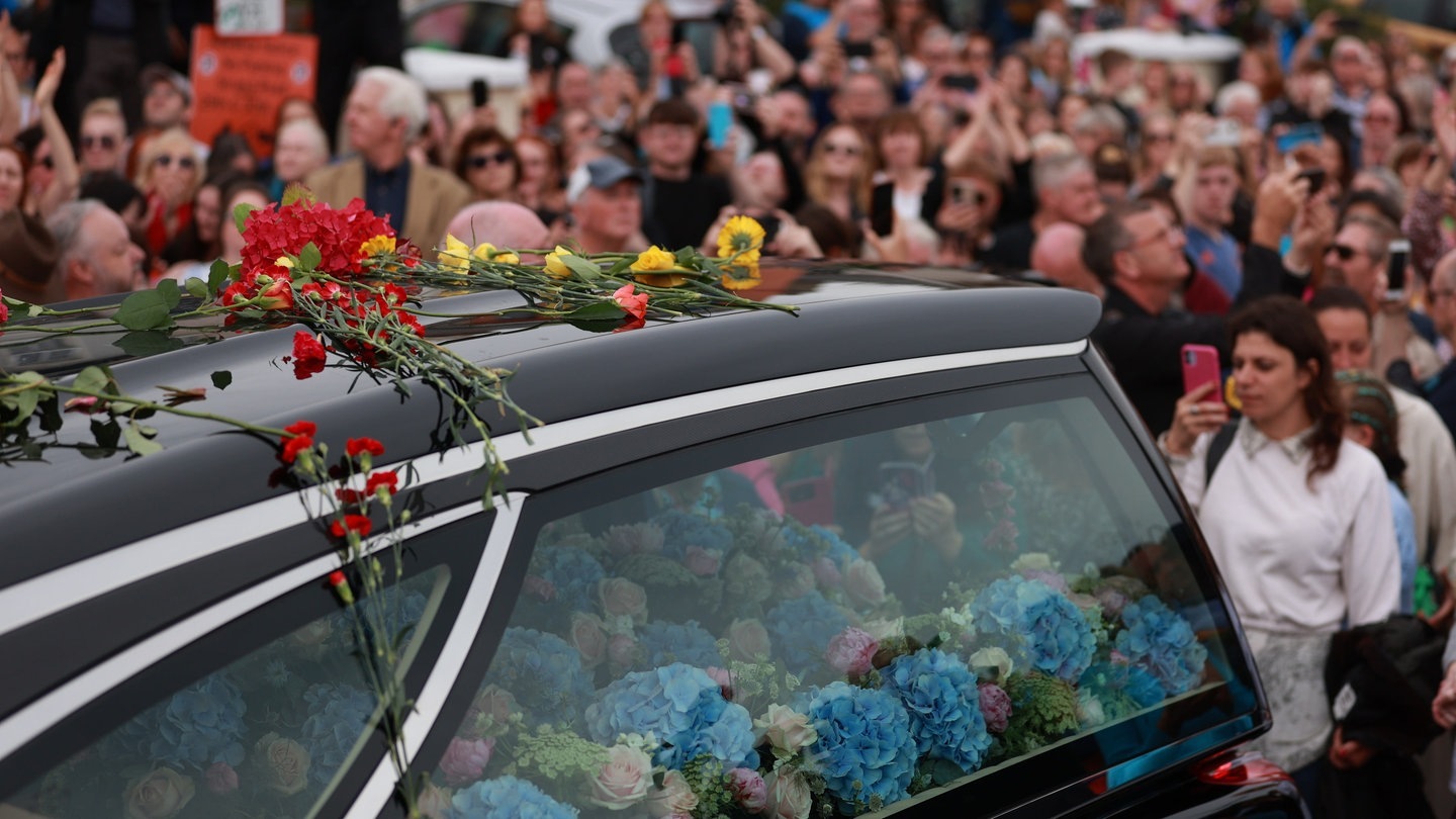 Foto: dpa Bildfunk, picture alliance/dpa/PA Wire | Liam Mcburney Fans der Sängerin Sinead O'Connor säumen eine Straßen, um sich ein letztes Mal von der irischen Sängerin zu verabschieden, als ihr Trauerzug vor der privaten Trauerfeier durch ihre frühere Heimatstadt fährt. (Foto: dpa Bildfunk, picture alliance/dpa/PA Wire | Liam Mcburney)