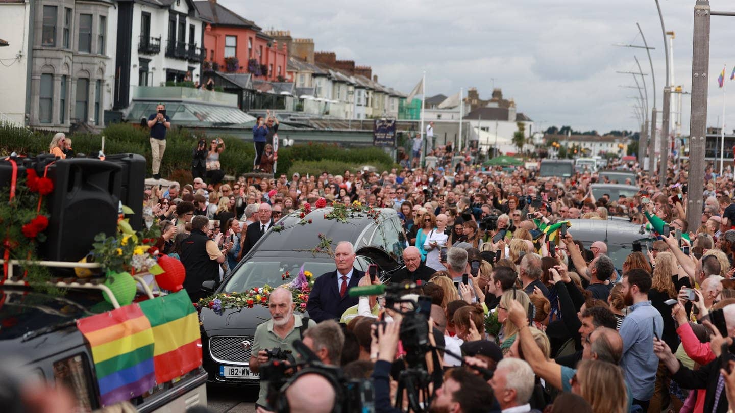 Fans der Sängerin Sinead O'Connor säumen die Straßen, um sich ein letztes Mal von der irischen Sängerin zu verabschieden, als ihr Trauerzug vor der privaten Beerdigung durch ihre frühere Heimatstadt fährt. (Foto: dpa Bildfunk, picture alliance/dpa/PA Wire | Liam Mcburney)