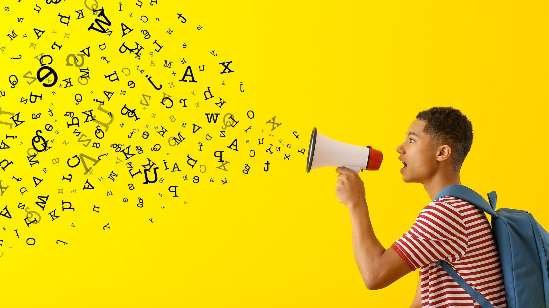 Ein Jugendlicher hält ein Megafon in der Hand und Buchstaben wirbeln umher (Foto: Adobe Stock, Pixel-Shot)