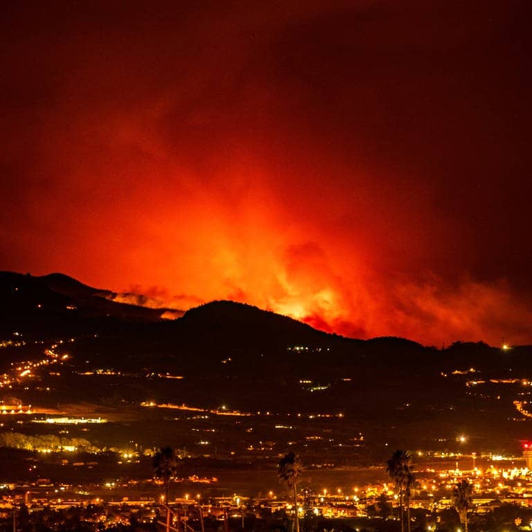 19. August 2023: Am Horizont sind Flammen zu sehen, während sich das Feuer durch den Wald auf die Stadt La Laguna und den Flughafen Los Rodeos zubewegt.  (Foto: dpa Bildfunk, picture alliance/dpa/AP | Arturo Rodriguez)