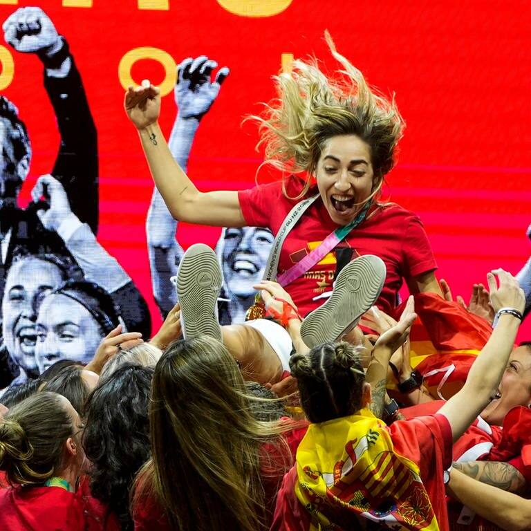 Spielerinnen der spanischen Frauenfußballnationalmannschaft heben die spanische Nationalspielerin Olga Carmona hoch, während sie auf der Bühne ihren Sieg bei der Fußballweltmeisterschaft feiern. (Foto: dpa Bildfunk, picture alliance/dpa/AP | Manu Fernandez)