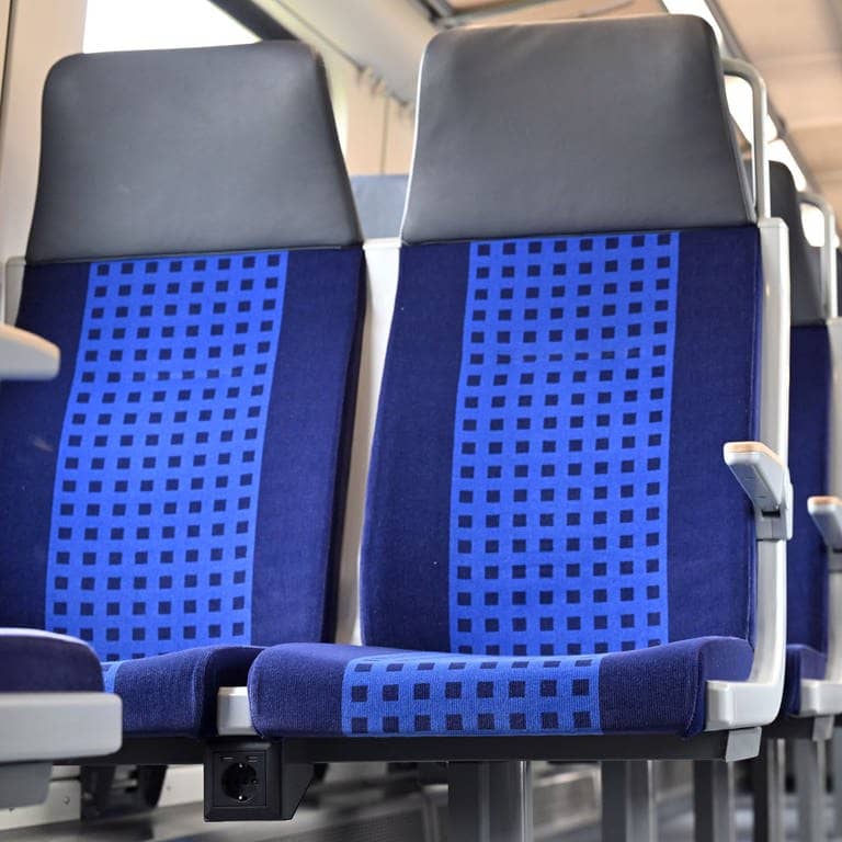 Eine Steckdose zwischen zwei Sitzplätzen in einem Regionalzug. Die Bundespolizei warnt vor manipulierten Steckdosen in Zügen.  (Foto: dpa Bildfunk, picture alliance/dpa | Martin Schutt)