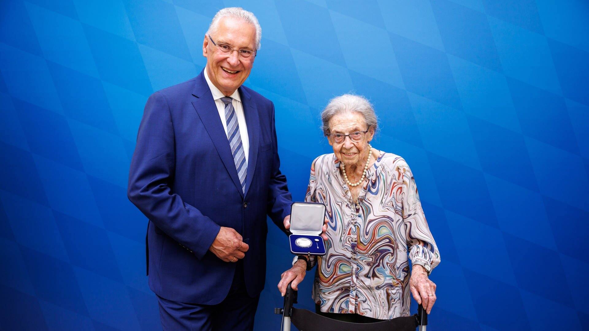 Bayerns Innenminister Joachim Herrmann überreicht 101-jähriger Margareta Fischer die Courage-Medaille, weil sie Enkeltrick-Betrüger ausgetrickst hat. (Foto: Matthias Balk, Bayerisches Staatsministerium)